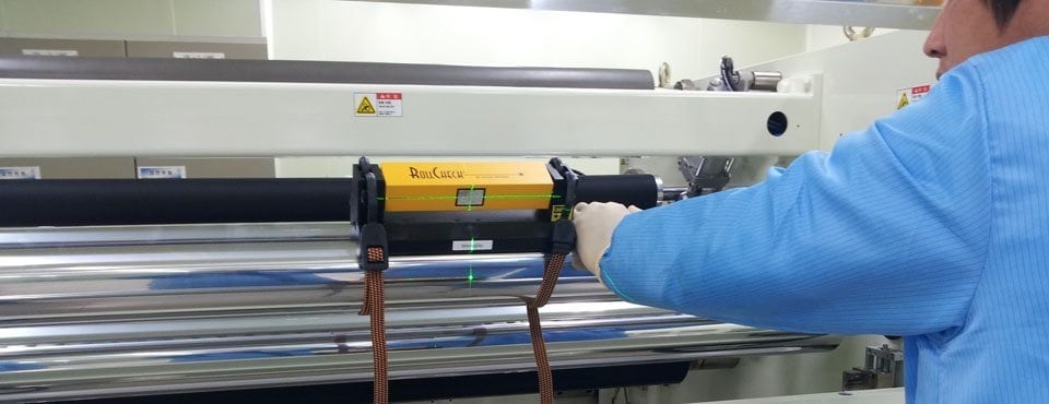 Worker using laser alignment tools to maintain machines 